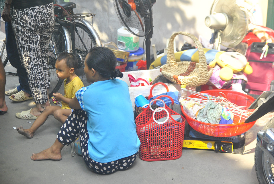 Có chút tiền dành dụm để dưới gối, người phụ nữ này chỉ kịp bồng theo đứa con nhỏ thoát khỏi đám cháy (Ảnh: Võ Phương/Vietnam+)