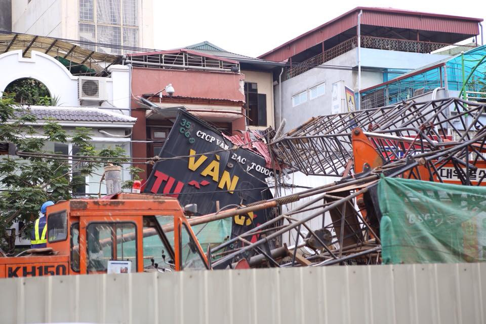 Vào khoảng 16 giờ 15 ngày 12/5, cần cẩu thi công dự án đường sắt đô thị đoạn chạy qua số nhà 359 Cầu Giấy bất ngờ bị gãy, đổ gục ra đường. Phần trên của cẩu đè thẳng vào biển hiệu của hiệu vàng Tuấn Đãi 359 Cầu Giấy. (Ảnh: Minh Sơn/Vietnam+)