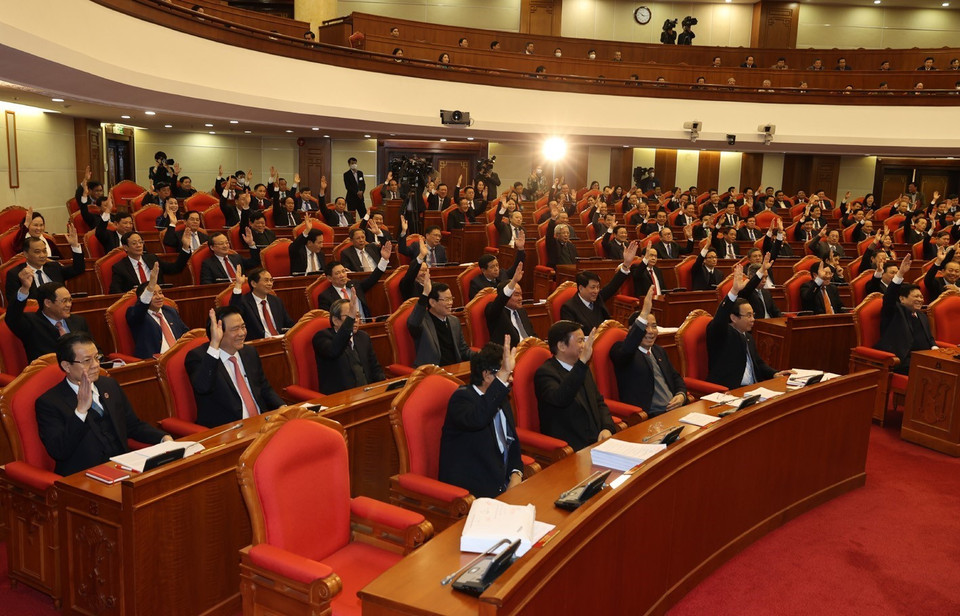 Các vị lãnh đạo Đảng, Nhà nước và các đại biểu biểu quyết thông qua Nghị quyết Hội nghị Trung ương lần thứ mười bốn. (Ảnh: Trí Dũng/TTXVN)