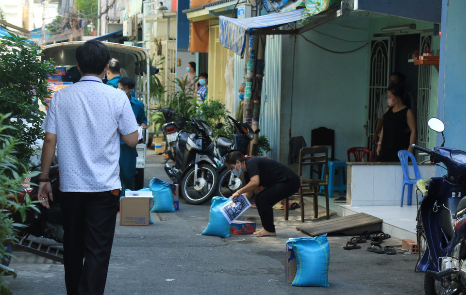 Người dân hẻm Lô E, Lò Gốm (Phường 7, Quận 6) nhận tiếp tế lương thực. (Ảnh: Đinh Hằng/TTXVN)