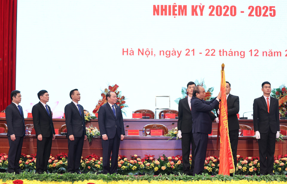 Thủ tướng Nguyễn Xuân Phúc gắn Huân chương Độc lập hạng Nhì lên lá cờ truyền thống của Liên minh Hợp tác xã Việt Nam. (Ảnh: Thống Nhất/TTXVN)