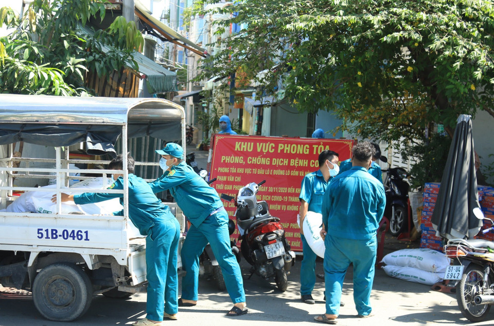 Lực lượng dân phòng vận chuyển lương thực tiếp tế cho người dân bị khu vực bị phong tỏa. (Ảnh: Đinh Hằng/TTXVN)