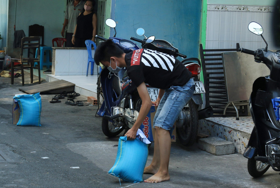 Người dân hẻm Lô E, Lò Gốm (Phường 7, Quận 6) nhận tiếp tế lương thực. (Ảnh: Đinh Hằng/TTXVN)