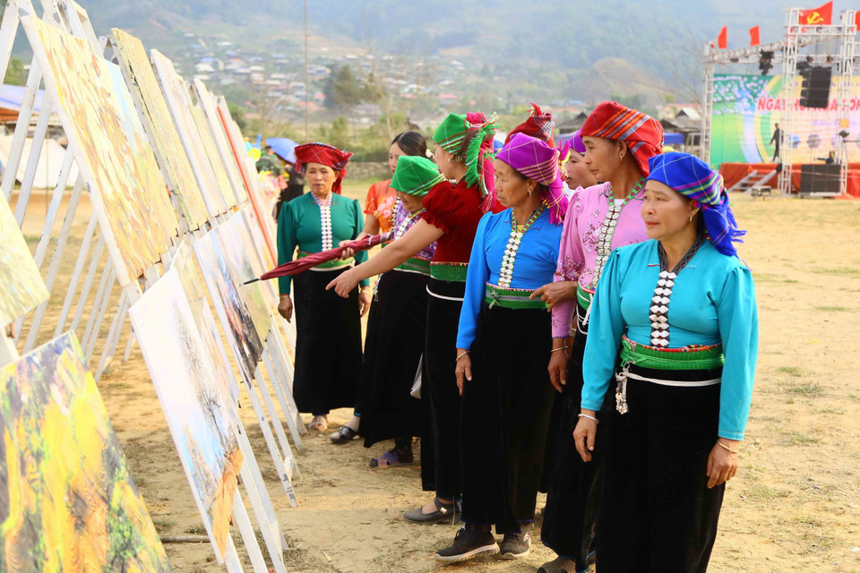 Đồng bào dân tộc Mông xã Ngọc Chiến tham quan triển lãm tranh, ảnh được sáng tác tại huyện Mường La. (Ảnh: Quang Quyết/TTXVN)