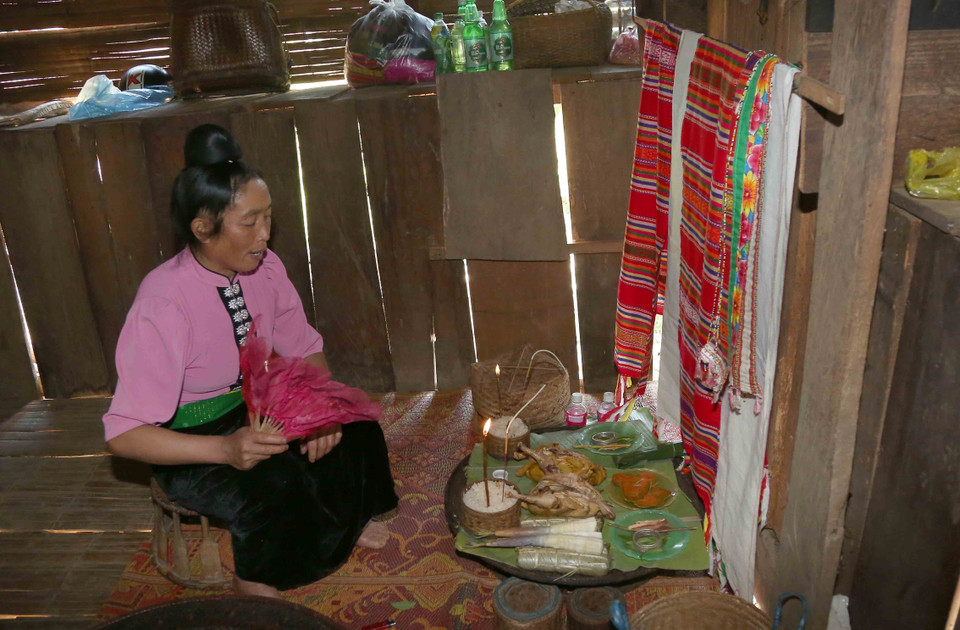 Thực hiện nghi lễ mời các vị thần linh thổ địa, linh hồn tổ tiên về dự và nhận các lễ vật của gia chủ. (Ảnh: Quang Quyết/TTXVN)