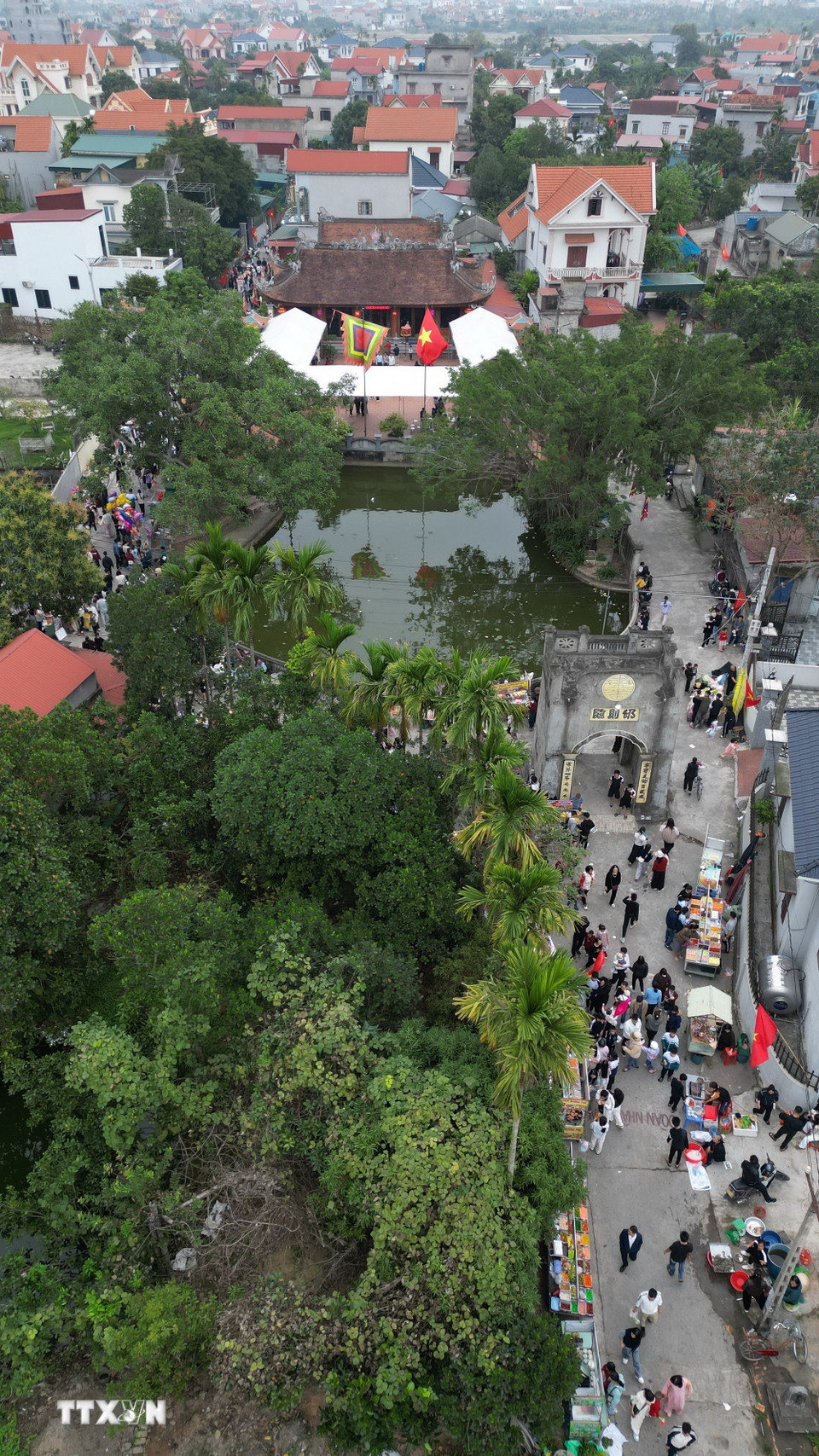 Đến hẹn lại lên, mùng 2 Tết, con đường dẫn vào khu vực Đình Cả ken đặc người. Hàng nghìn người dân xã Vĩnh Lại cùng các địa phương lân cận đổ về đi chợ Tết, du xuân, cầu phúc, cầu lộc. (Ảnh: Minh Quyết/TTXVN)