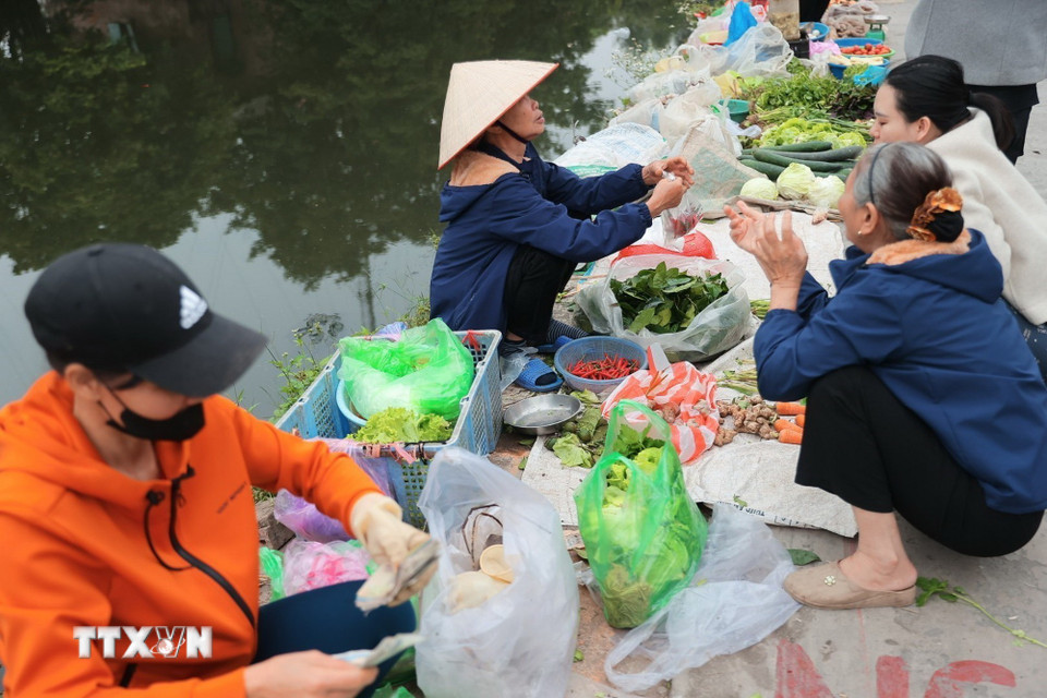 Chợ bán đủ các mặt hàng thiết yếu, từ thịt, cá, rau dưa, bún, hải sản đến những vật dụng nhỏ bé, quen thuộc của đời sống gia đình như cây kim, sợi chỉ. Trong đó, bún, rau sống, cau trầu, muối là những mặt hàng được tìm mua nhiều nhất, những thứ giản dị nhưng mang ý nghĩa cầu đủ đầy, mặn mà cho năm mới. (Ảnh: Minh Quyết/TTXVN)