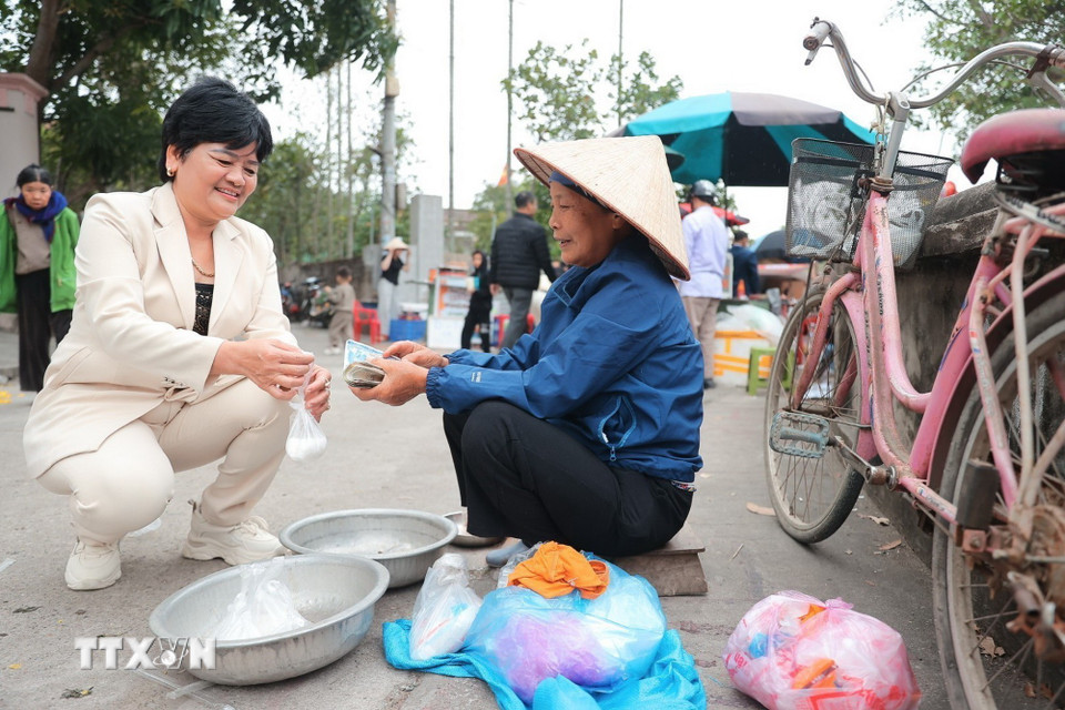 Phiên chợ mùng 2 Tết cũng là cơ hội để mọi người có thời gian mua sắm cho dịp Tết và cũng để cầu cho một năm buôn bán thuận lợi. (Ảnh: Minh Quyết/TTXVN)