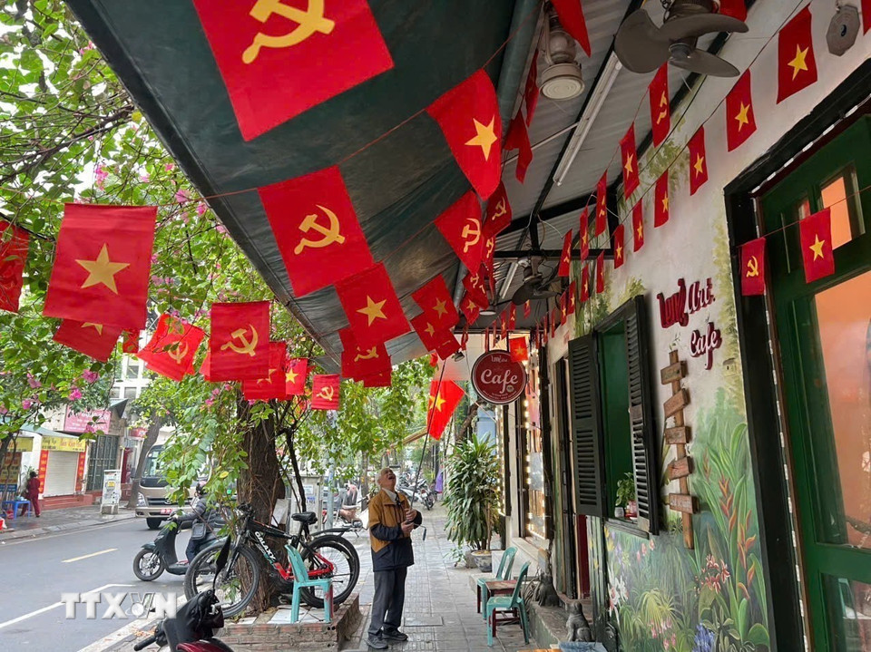 Ông Nguyễn Xuân Điệu, đảng viên có 52 năm tuổi Đảng (phường Hai Bà Trưng, Hà Nội) trang trí cờ hoa chào mừng Đại hội lần thứ XIV của Đảng. (Ảnh: Vũ Quang/TTXVN)