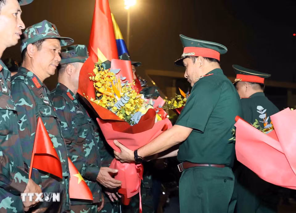 Lãnh đạo Bộ Quốc phòng tặng hoa chúc mừng đoàn. (Ảnh: An Đăng/TTXVN)