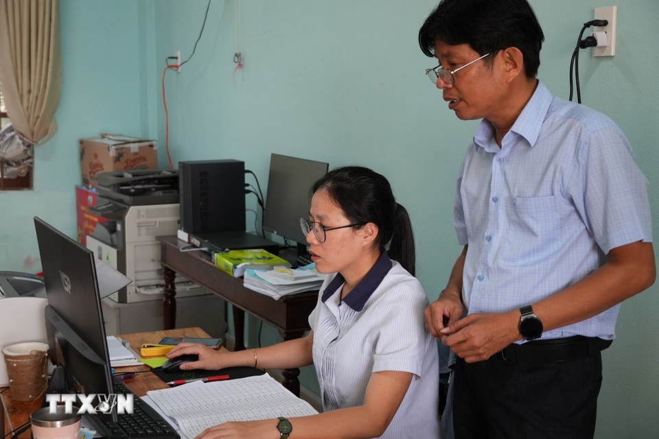 Cán bộ Ủy ban Bầu cử xã Tân Hiệp tiếp tục rà soát danh sách cử tri trên địa bàn xã. (Ảnh: Đỗ Trưởng/TTXVN)