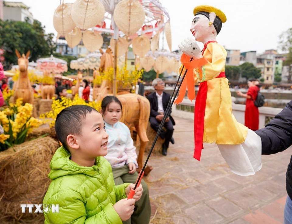 Du khách trải nghiệm điều khiển trực tiếp các con rối. (Ảnh: Khánh Hòa/TTXVN)