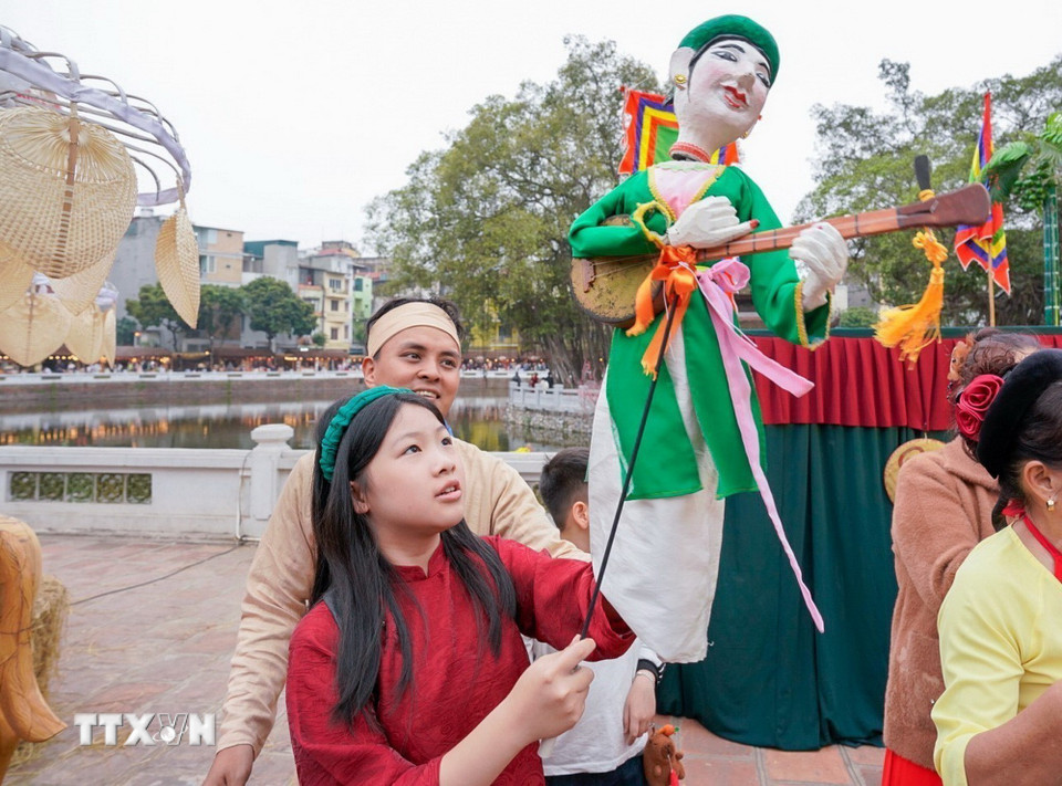 Du khách trải nghiệm điều khiển trực tiếp các con rối.(Ảnh: Khánh Hòa/TTXVN)