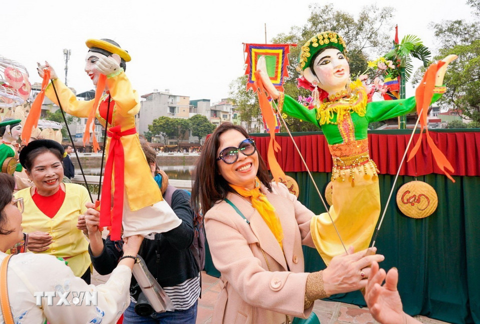 Người dân trải nghiệm điều khiển trực tiếp các con rối. (Ảnh: Khánh Hòa/TTXVN)