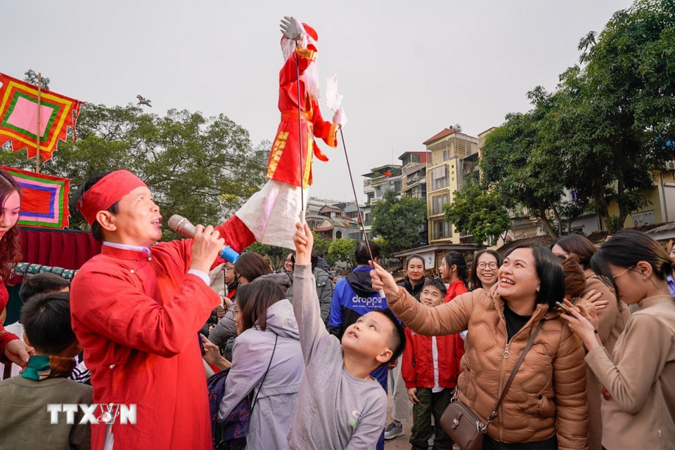 Người dân trải nghiệm điều khiển trực tiếp các con rối. (Ảnh: Khánh Hòa/TTXVN)