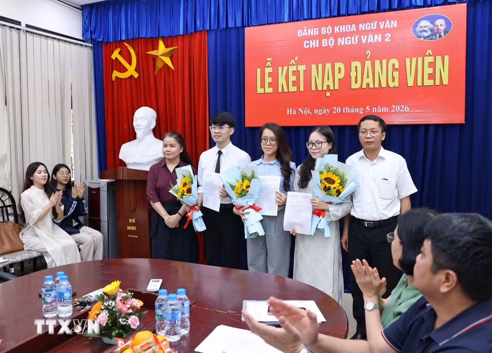 Lãnh đạo Đảng uỷ Khoa Ngữ văn tặng hoa chúc mừng 3 đảng viên mới được kết nạp của Chi bộ Ngữ văn 2. (Ảnh: Thanh Tùng/TTXVN)