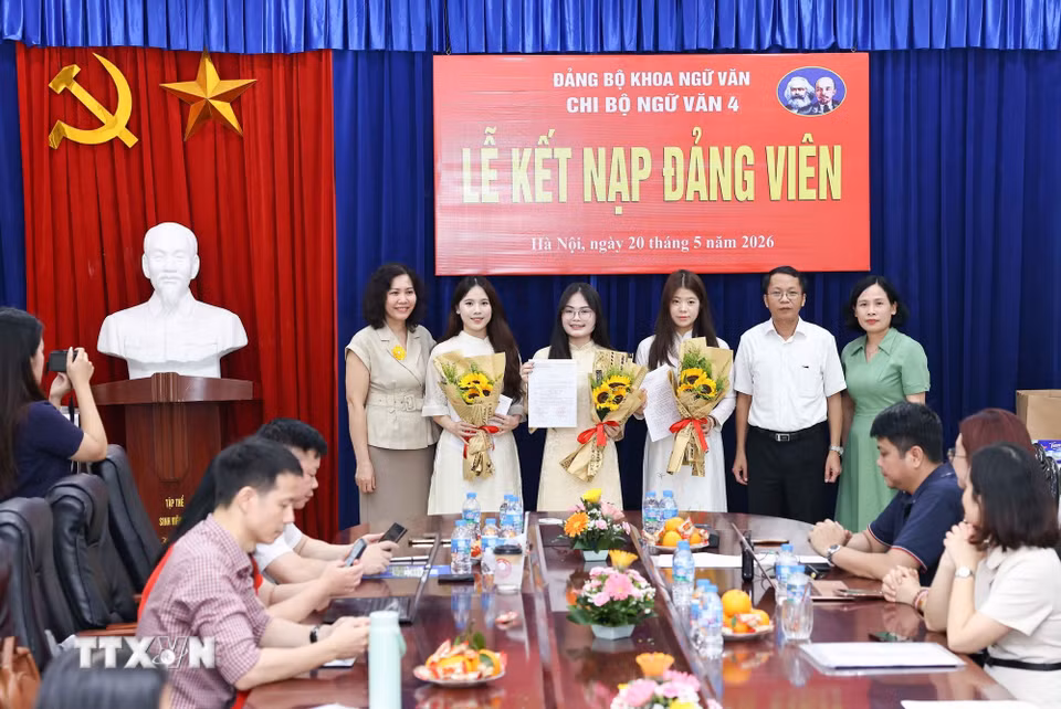 Lãnh đạo Đảng ủy Khoa Ngữ văn tặng hoa chúc mừng 3 đảng viên mới được kết nạp của Chi bộ Ngữ văn 4. (Ảnh: Thanh Tùng/TTXVN)