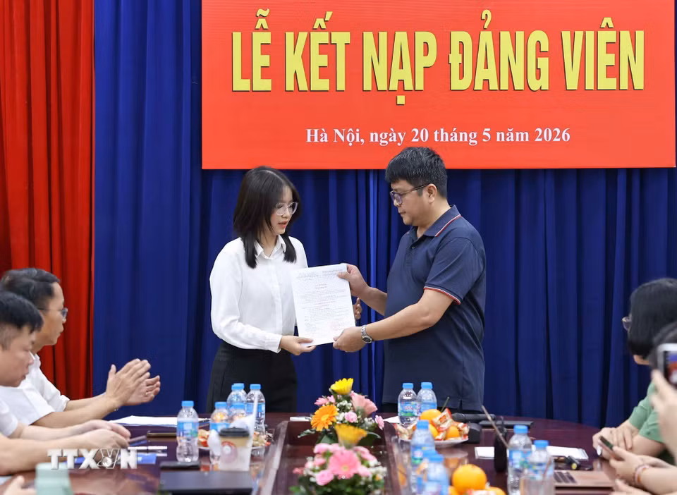 Bí thư Chi bộ Ngữ văn 3 trao quyết định kết nạp cho đảng viên mới. (Ảnh: Thanh Tùng/TTXVN)