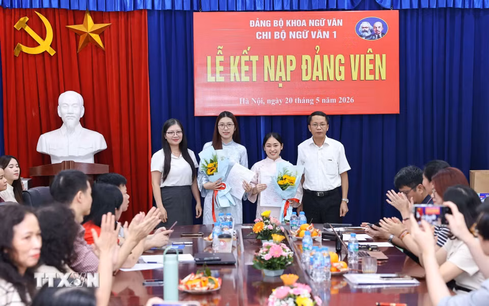 Lãnh đạo Đảng ủy Khoa Ngữ văn tặng hoa chúc mừng 2 đảng viên mới được kết nạp của Chi bộ Ngữ văn 1. (Ảnh: Thanh Tùng/TTXVN)
