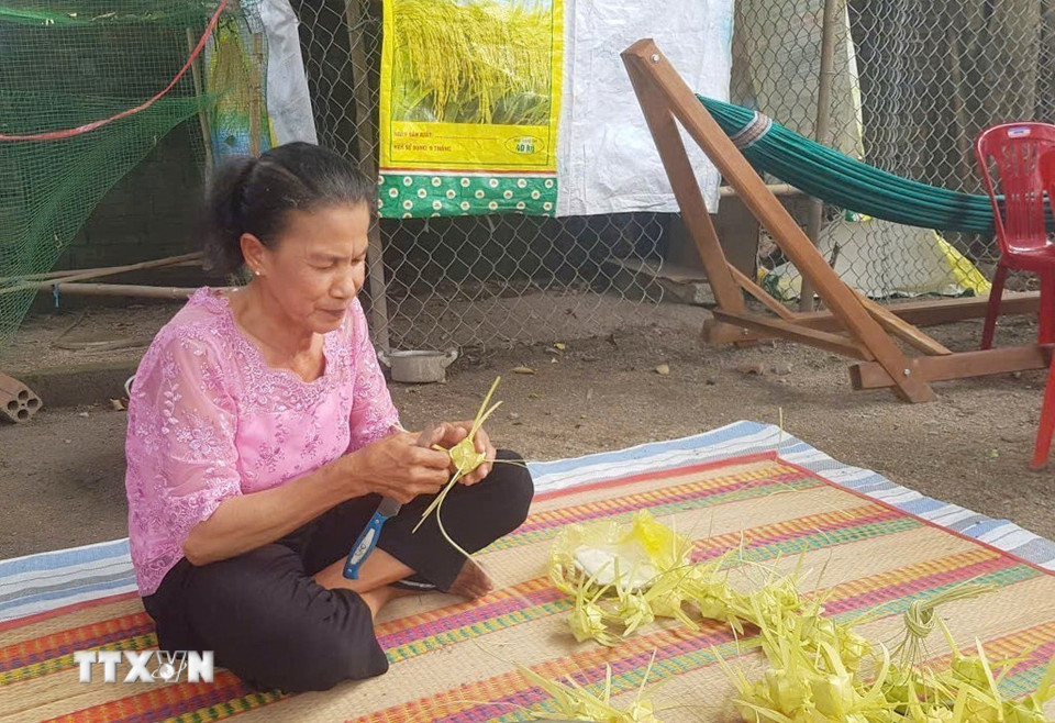 Nghệ nhân Néang Phương tỉ mỉ đan từng chiếc vỏ bánh Kà tum, thể hiện sự khéo léo từ đôi bàn tay của người phụ nữ dân tộc Khmer. (Ảnh: Công Mạo/TTXVN)