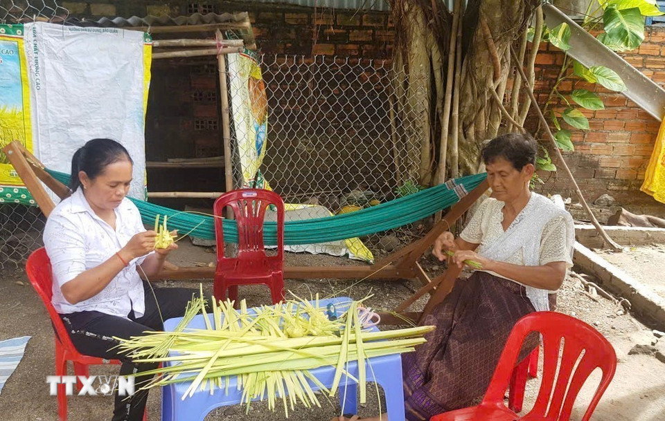 Chị em phụ nữ người dân tộc Khmer trên địa bàn xã Ô Lâm học cách đan vỏ bánh Kà tum tại nhà của Nghệ nhân Néang Phương. (Ảnh: Công Mạo/TTXVN)