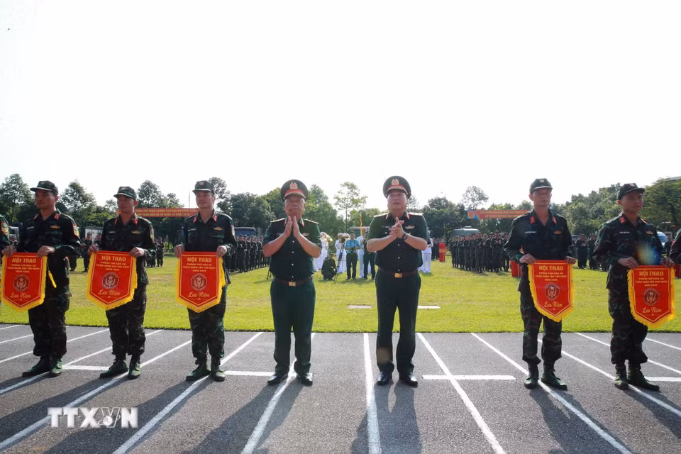 Thượng tướng Nguyễn Quang Ngọc, Ủy viên Trung ương Đảng, Thứ trưởng Bộ Quốc phòng tặng cờ các đơn vị tại lễ khai mạc. (Ảnh: Trọng Đức/TTXVN)