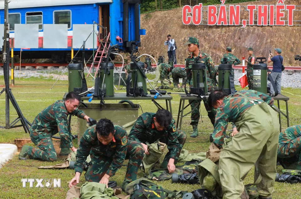 Lực lượng hóa học thu dọn quân trang sau khi thực hiện bài thi tẩy trùng hiện trường bị nhiễm chất độc hại. (Ảnh: Trọng Đức/TTXVN)