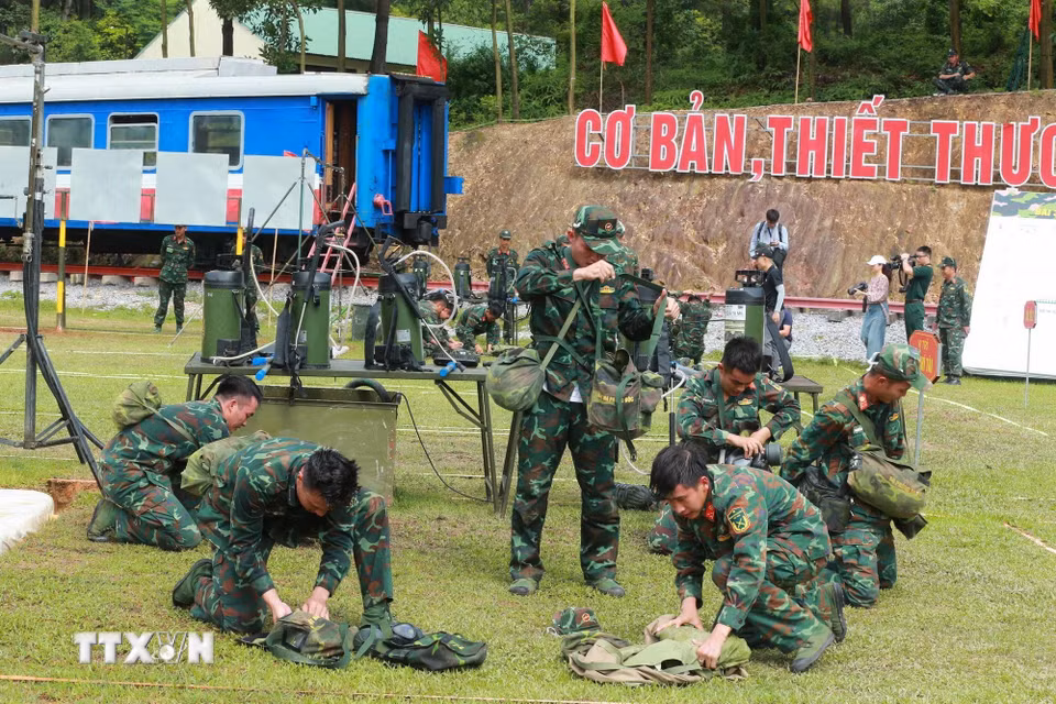 Lực lượng hóa học thu dọn quân trang sau khi thực hiện bài thi tẩy trùng hiện trường bị nhiễm chất độc hại. (Ảnh: Trọng Đức/TTXVN)