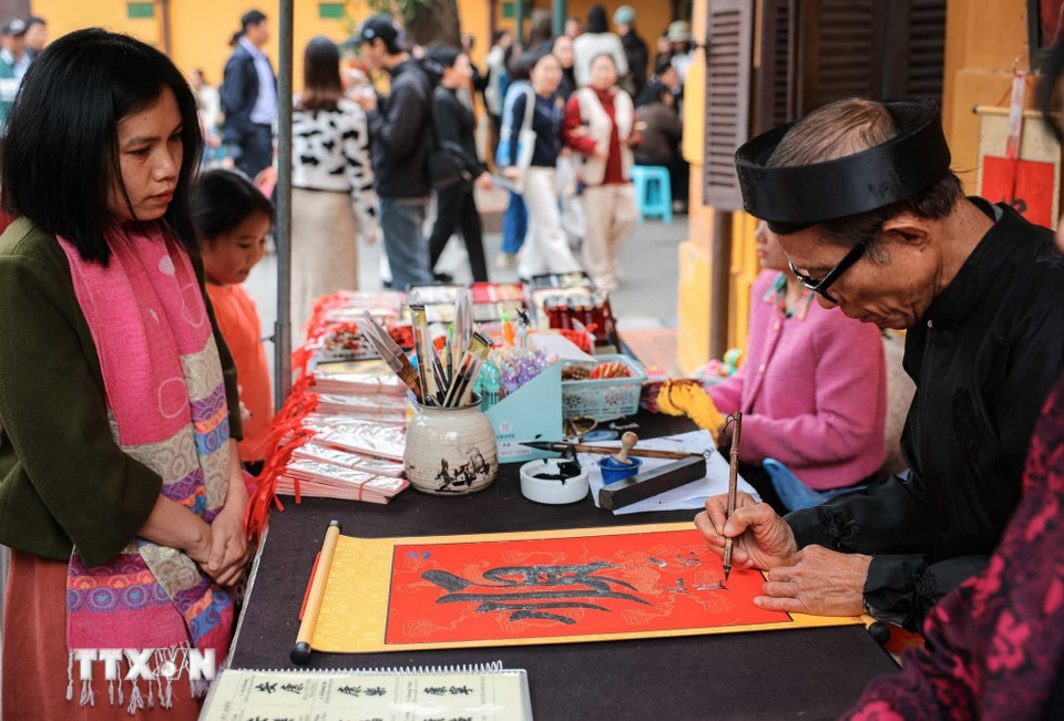 Người dân xin chữ đầu năm trong khu di tích Chủ tịch Hồ Chí Minh. (Ảnh: Hoàng Hiếu/TTXVN)