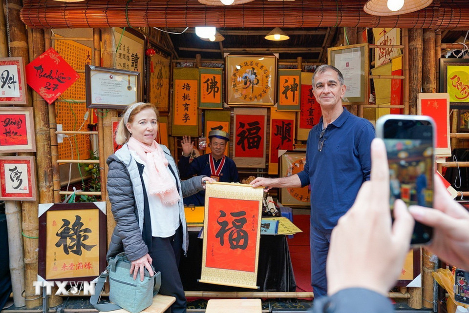 Du khách thích thú với phong tục xin chữ đầu năm của người Việt. (Ảnh: Khánh Hòa/TTXVN)