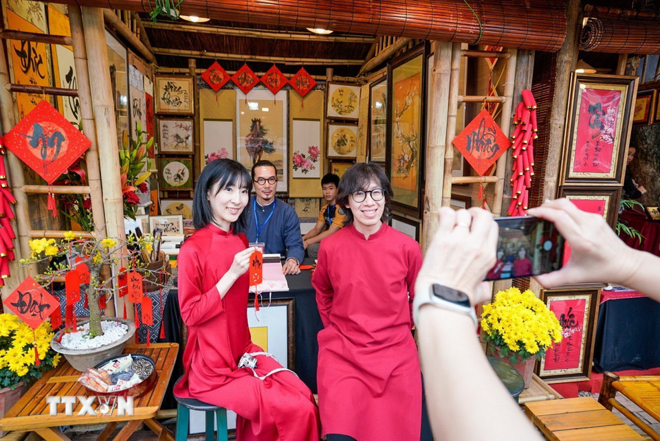 Du khách thích thú với phong tục xin chữ đầu năm của người Việt. (Ảnh: Khánh Hòa/TTXVN)