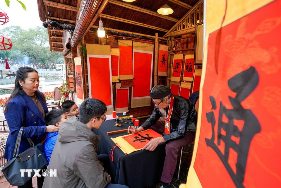Người dân xin chữ tại Không gian Hồ Văn, Di tích Quốc gia đặc biệt Văn Miếu-Quốc Tử Giám (Hà Nội) ngày mùng 2 Tết Bính Ngọ. (Ảnh: Khánh Hòa/TTXVN)