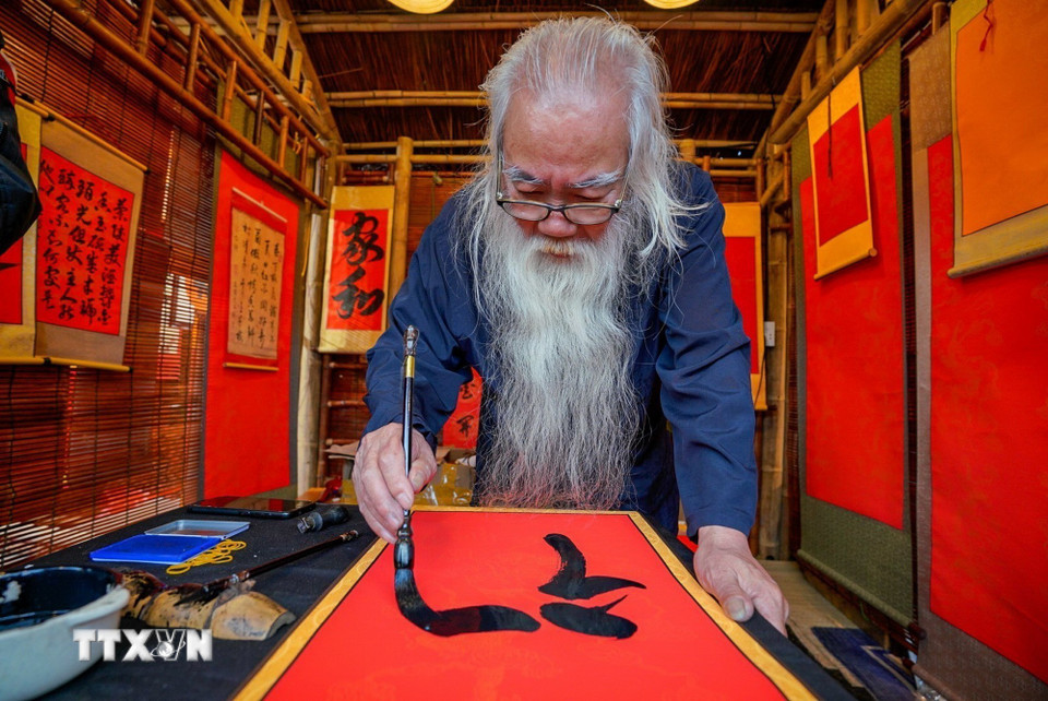 Cứ mỗi độ Xuân về, hình ảnh ông đồ già mực tàu giấy đỏ lại trở nên quen thuộc, mang theo những con chữ gửi gắm lời chúc phúc, may mắn và tài lộc. (Ảnh: Khánh Hòa/TTXVN)