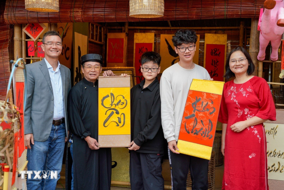 Một gia đình xin chữ đầu năm tại Không gian Hồ Văn, Di tích Quốc gia đặc biệt Văn Miếu-Quốc Tử Giám (Hà Nội) ngày mùng 2 Tết Bính Ngọ. (Ảnh: Khánh Hòa/TTXVN)