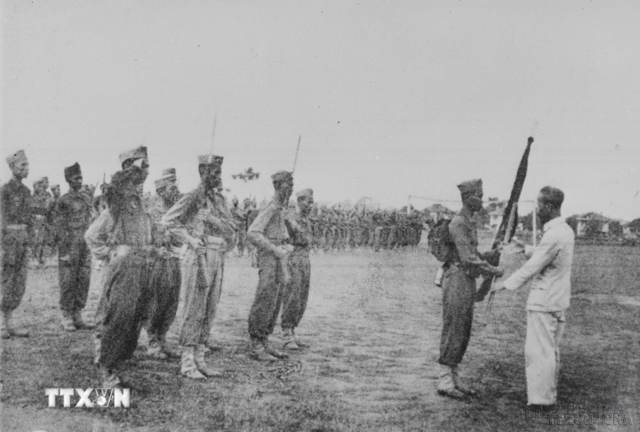 Hồ Chủ tịch trao cờ thêu dòng chữ “Trung với nước, hiếu với dân” cho học viên khóa I trường Lục quân Trần Quốc Tuấn (22/4/1946). (Ảnh: Tư liệu TTXVN)