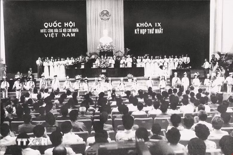Quốc hội khóa IX (1992-1997) được bầu ngày 19/7/1992, gồm có 395 đại biểu, nhiệm kỳ hoạt động là 5 năm. Đồng chí Nông Đức Mạnh được bầu làm Chủ tịch Quốc hội. Quốc hội khóa IX đã đóng vai trò quan trọng trong việc thể chế hóa Cương lĩnh xây dựng đất nước trong thời kỳ quá độ lên chủ nghĩa xã hội, Chiến lược ổn định và phát triển kinh tế - xã hội, đường lối đổi mới của Đảng theo tinh thần Hiến pháp năm 1992 và Nghị quyết của Đại hội Đảng toàn quốc lần thứ VII. Trong ảnh: Đoàn thiếu nhi Thủ đô đến chào mừng các đại biểu Quốc hội khóa IX trong phiên khai mạc Kỳ họp thứ nhất, ngày 20/9/1992. (Ảnh: TTXVN)