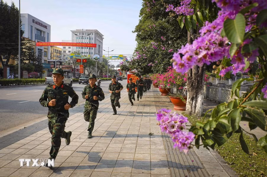 Chiến sỹ luyện tập trên tuyến phố rợp sắc hoa bằng lăng. (Ảnh: Xuân Tư/TTXVN)