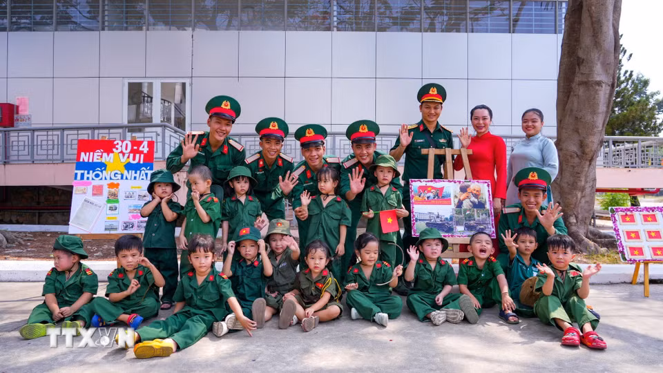 Tập thể cán bộ, chiến sỹ Trung đoàn 4, Sư đoàn 5 và các em nhỏ chụp ảnh lưu niệm, thể hiện sự gắn kết giữa đơn vị quân đội với nhà trường. (Ảnh: Minh Phú/TTXVN)