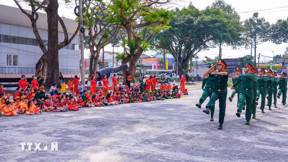 Các em nhỏ xem các chiến sỹ biểu diễn động tác điều lệnh đội ngũ trong chương trình ngoại khóa. (Ảnh: Minh Phú/TTXVN)
