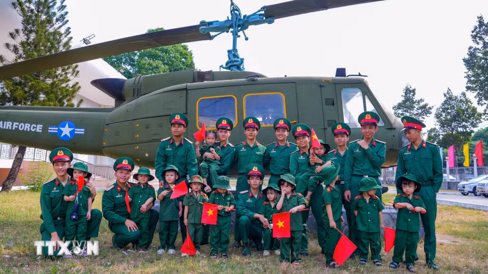 Các em nhỏ tìm hiểu về trang thiết bị quân sự trong chương trình ngoại khóa. (Ảnh: Minh Phú/TTXVN)