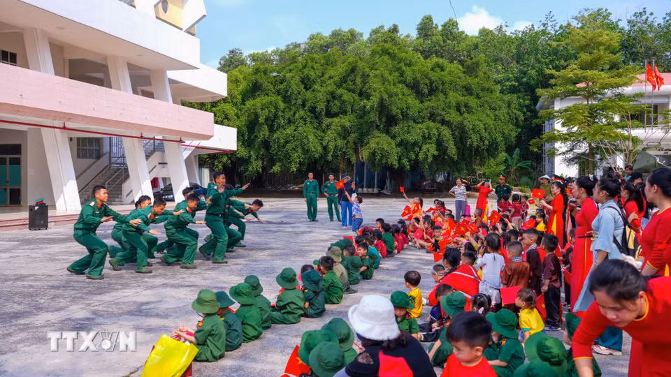 Học sinh và giáo viên xem Chiến sỹ Trung đoàn 4, Sư đoàn 5 biểu diễn tiết mục truyền thống cách mạng. (Ảnh: Minh Phú/TTXVN)
