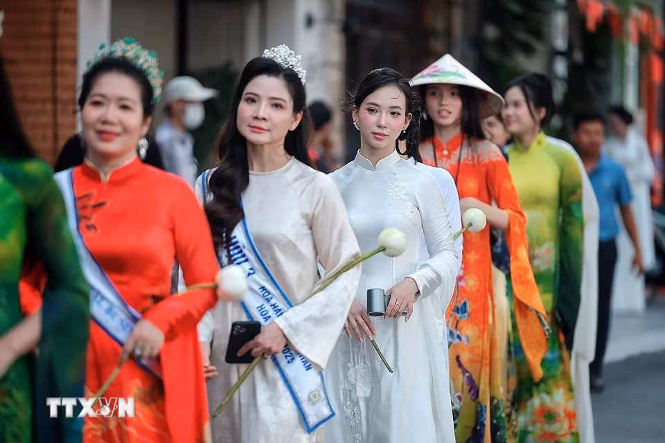 Những tà áo dài rực rỡ sắc sen nối dài trong đoàn diễu hành nghệ thuật “Sắc Sen Tây Hồ - Hà Nội." (Ảnh: Phạm Tuấn Anh/TTXVN)