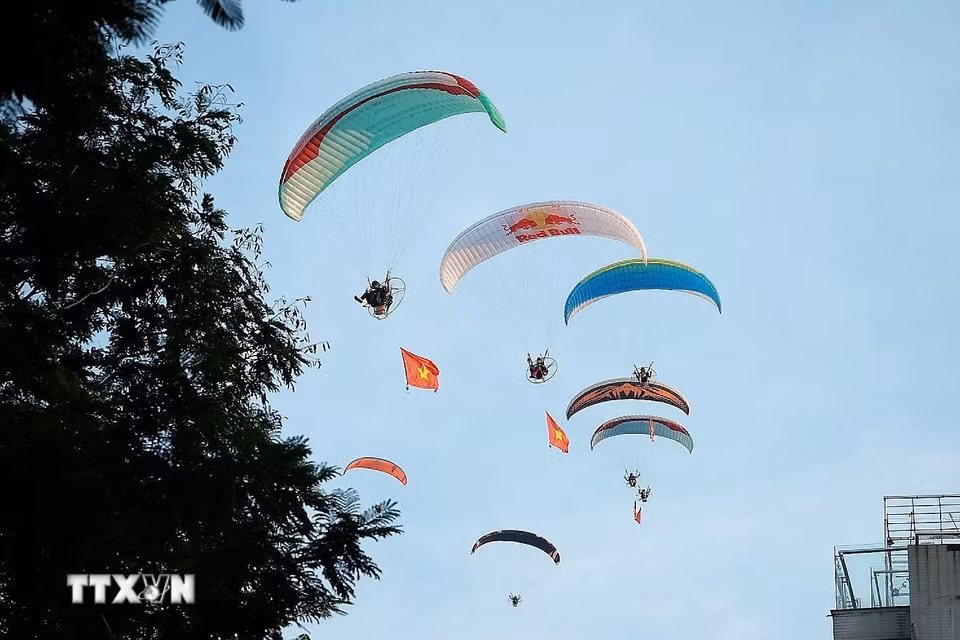 Tiết mục bay dù lượn mang theo cờ Tổ quốc trên bầu trời Hồ Tây, tạo điểm nhấn sinh động trong không gian văn hóa-du lịch của Lễ hội Sen Hà Nội năm 2026. (Ảnh: Phạm Tuấn Anh/TTXVN)