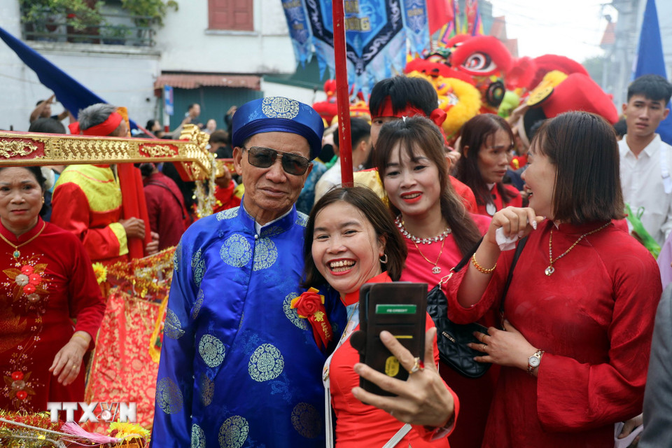 Con cháu cùng lưu lại những khoảnh khắc đáng nhớ với các cụ thượng thọ. (Ảnh: Đức Hiếu/TTXVN)