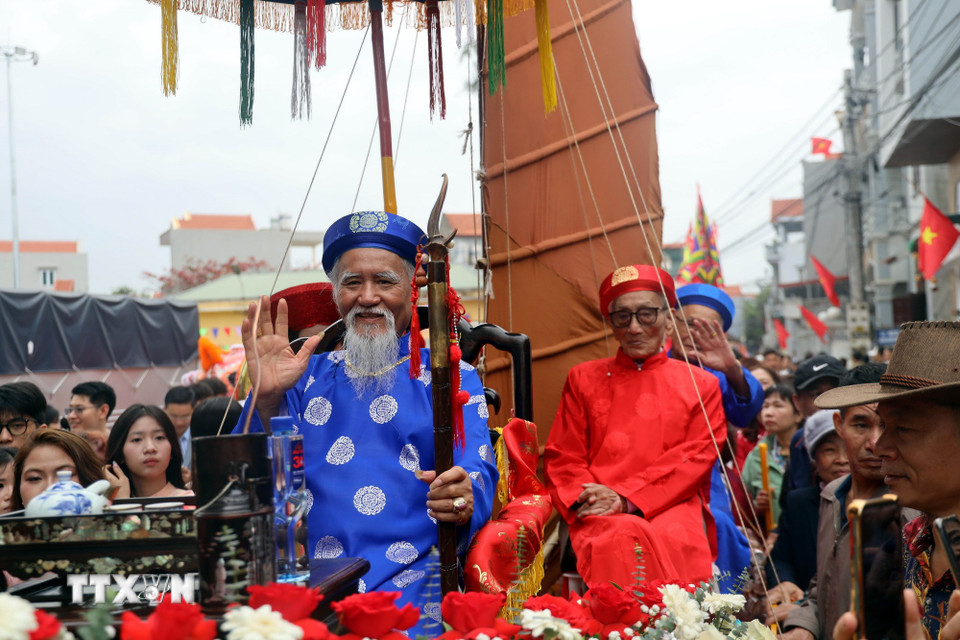 Cụ ông Vũ Văn Oanh (hàng đầu áo xanh), phường Phong Cốc, tỉnh Quảng Ninh, tròn 80 tuổi và được con cháu rước lên miếu Tiên Công. (Ảnh: Đức Hiếu/TTXVN)