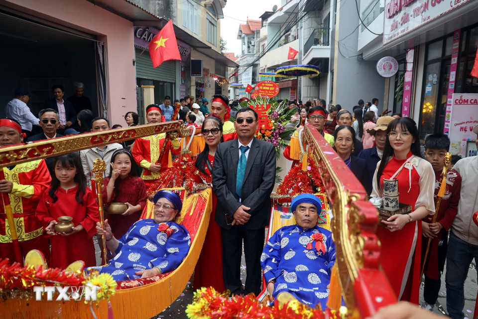 Cặp song thượng thọ cụ ông Ngô Văn Gắt và cụ bà Lê Thị Thế, phường Liên Hòa (tỉnh Quảng Ninh), cùng đạt 80 tuổi được con cháu rước trên võng đào lên miếu Tiên Công. (Ảnh: Đức Hiếu/TTXVN)