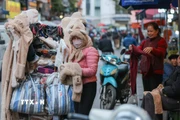 Người lao động, bán hàng trên phố che chắn kỹ chống rét. (Ảnh: Hoàng Hiếu/TTXVN)