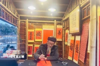 Ông đồ cho chữ tại Hội chữ Xuân Bính Ngọ 2026 trong không gian Hồ Văn, di tích quốc gia đặc biệt Văn Miếu-Quốc Tử Giám. (Ảnh: Tuyết Mai/TTXVN)