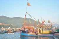Mở đầu lễ hội là nghi thức nghinh Ông trên biển. Từ sáng sớm, đoàn ghe được trang hoàng cờ hoa rực rỡ xuất phát từ bến cá Vĩnh Trường, tiến ra khu vực mũi Phủ Ông. (Ảnh: TTXVN phát)