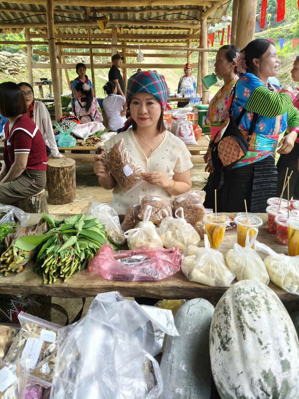 Sau giờ lên lớp, cô giáo Lê Thị Kim Liên lại trở thành cô gái bản xinh đẹp, xuống chợ mua bán cùng người đồng bào dân tộc. (Ảnh: Khánh Ly/Vietnam+)
